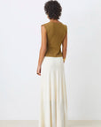 A person with short curly hair faces away, wearing the SUNCOO PAGNI S/L button front jumper in olive green and a long white skirt, set against a plain white background.