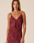 Red floral Natalie Martin Heath Cami dress, styled in a minimal setting, model facing forward.