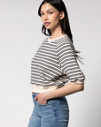 A woman with long dark hair models the Perfectwhitetee French Terry SS Raglan Sweatshirt with short sleeves, paired with blue jeans, posing in profile against a plain light background.