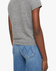 A person is shown from the back wearing Mother’s The Lil Goodie Goodie Tee in soft gray with light blue jeans, paired casually with a thin gold bracelet on their relaxed left arm.