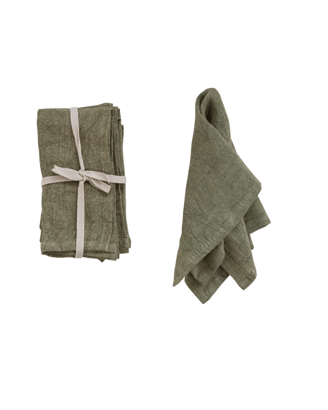 Two Stonewashed Linen Napkins by Creative Co-op on a white background in a Scottsdale bungalow; one neatly folded and tied with a ribbon, the other casually draped and partially unfolded.
