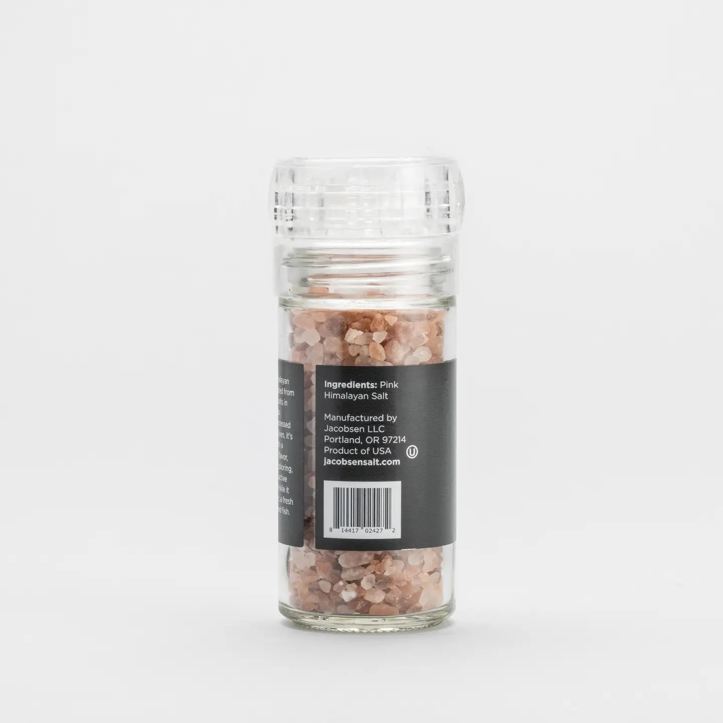 The Faire Pink Himalayan Salt Grinder features coarse Himalayan salt crystals in a refillable glass grinder with a clear plastic top and a black label, displayed simply against a plain white background.