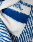 A close-up of soft, woven blue and white stripes with layered, fuzzy textures—handcrafted by Mayan artisans for the Selene Momo Blanket by Jitana Wholesale.