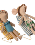 Two Maileg Mouse dolls from Maileg relax on Maileg Furniture: one in a blue swimsuit on a yellow chair and the other in green plaid shorts on a blue chair, both wearing sun hats and beach outfits.