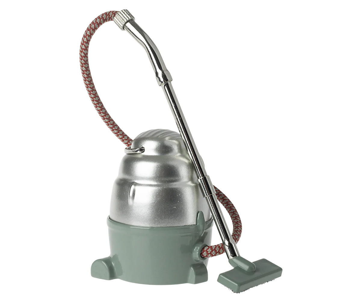 Maileg Furniture by Maileg: a vintage-inspired canister vacuum cleaner with silver top, green base, metal hose, and fabric-wrapped cord—ideal for dollhouse displays or Maileg Mouse scenes—stands upright on a neutral background.