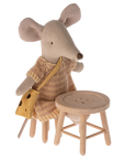A Maileg Mouse plush doll with a knitted dress and yellow bag sits on Maileg Furniture next to a matching stool, both by Maileg, against a plain background.
