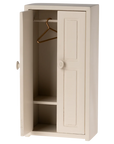 The Maileg Furniture wardrobe by Maileg is a small, off-white wooden piece with one door open, showing two shelves and a metal hanger—ideal for Maileg Mouse dollhouses or miniature room decor.