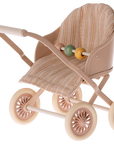 Maileg Furniture by Maileg: A small toy stroller with beige and pink tones, four decorative wheels, a striped seat, and three colorful beads—perfect for Maileg Mouse dollhouse play.