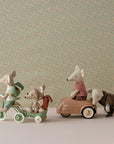 Toy mice with magnetic paws ride tricycles by a floral backdrop, Maileg Abri a Tricycle collection.