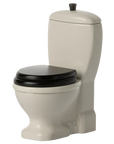 The Maileg Furniture white toilet by Maileg features a black seat and lid, standard tank, and flush handle—ideal for dollhouse displays or your Maileg Mouse collection. Presented against a plain background.