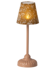 The Maileg Furniture table lamp by Maileg features a beige floral-patterned lampshade and a pink, rounded base—ideal for Maileg Mouse dollhouses and elegantly set against a neutral background.