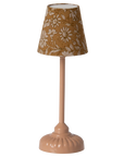 The Maileg Furniture table lamp by Maileg features a pink base and a brown lampshade with white floral patterns—a charming accessory for any dollhouse.