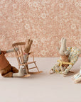 Maileg bunnies on Micro Babysitter seats with floral wallpaper, playful nursery decor from Bungalow Furniture & Accessories.