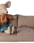 Maileg Furniture by Maileg features a mouse in a striped orange shirt and blue shorts sitting on a small plaid sofa with matching cushion—perfect for charming dollhouse furniture or any cute collection.