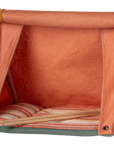 The Maileg Happy Camper Mouse Tent by Maileg is a small orange fabric tent with a roll-up front flap, striped cushion inside, and wooden poles—ideal for imaginative play and outdoor adventures on any flat surface.