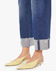 A person wears Mother’s The Half-Pipe Ankle Cuff Fray high-waisted barrel jeans and pale yellow slingback kitten heels with a bow, standing against a white background.