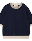 The Many Contrast T-Shirt by Jumper 1 2 3 4/CR2 is a navy cashmere short sleeve jumper with beige ribbed trim on the collar, cuffs, and hem, shown on a white background.