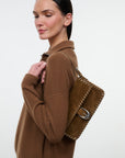 Staud Harlow Bag in brown suede with stitching detail and silver buckle, carried over shoulder with casual style.