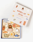 The "Jesus Wooden Puzzle" by Faire, crafted from poplar wood, includes pieces resembling a loaf of bread, fish, lamb, net, starburst, crown, and a person. The lid features these symbols in red text and acts as a storage box.
