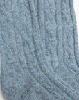 Close-up of Faire Wool Speckled Knit Socks in light blue, made from a wool-blend with a ribbed texture and multicolored specks throughout.