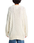 A person with short dark hair, seen from behind, wears the Denimist OVERSIZED ARAN SWEATER in cream heavyweight cotton knit fabric, paired with blue jeans.