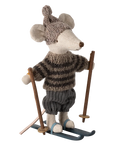 The Maileg Mouse by Maileg is dressed in a striped sweater, knitted pom-pom hat, and pants, standing on blue skis with ski poles—ideal for fun adventures with the mice family!.
