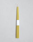 A pair of 18" Taper Candles by The Floral Society in yellow, crafted from premium materials, are joined at the wicks with a white label and displayed on a light gray background.