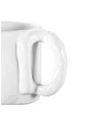 Close-up of a Montes Doggett Mug No. 205 focusing on its handle, with a plain white background indicative of a Scottsdale Arizona bungalow, highlighting the glossy finish and simplicity of the design.
