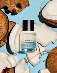 A bottle of Faire Heretic 50ML Perfume is displayed among cracked coconut pieces on a light blue background.
