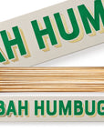 A rectangular Faire Long Safety Matches box displays "BAH HUMBUG" in bold green and yellow letters. Showcasing a unique design, the open box reveals long wooden matches with white tips neatly arranged inside.