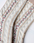 The Faire Vintage Stripe Floral Socks feature a cream knit with beige toes and cuffs, decorated with pink embroidered flowers and green stems along vertical stripes.