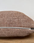 A close-up of the Faire Alora Woven Linen Havana pillow, featuring a visible silver zipper and plush down feather insert, shown on a wooden surface with a plain white background.