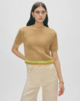A woman with long dark hair wears a White + Warren Organic Cotton Mesh Tshirt and high-waisted off-white pants, standing against a plain light background.