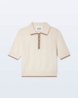 The White + Warren Cashmere Button Down Polo is a cream short-sleeve top with a ribbed collar, cuffs, and hem, accented by brown trim along the edges and button placket.