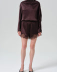 Lace trimmed tap shorts by Citizens of Humanity, paired with a satin long-sleeve top and black heels.