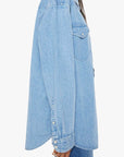 A person with long dark hair wears "The Exes And The Ohs" shirt by Mother in light blue denim, featuring buttoned cuffs and a chest pocket. Paired with vintage-blue wash jeans, they are set against a plain white background.