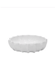 A white, ceramic Bowl No. 727 by Montes Doggett shaped like a flower with petals, set against a plain white background in a Scottsdale Arizona bungalow.