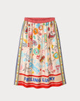 The Vanessa Midi Skirt by Me369 is a colorful viscose midi skirt featuring playful illustrations of dice, stars, and hearts. It includes an elastic waist and a red polka dot waistband with decorative trim on the sides, perfectly pairing with a matching shirt for a fun game-themed look.