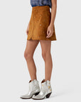 Hunter Bell NYC Dottie Skirt paired with a blue patterned top and silver studded cowboy boots.