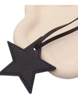 The Faire Bag Charm is a black leather, star-shaped accessory with a matching strap—ideal as a personal touch or chic handbag accent—displayed on a smooth cream surface.