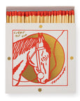 A box of Matches/Square by Faire features red-tipped matches and a cover with a red and gold illustrated horse head, encircled by gold stars, and the words "LIGHT ME UP" above the design.