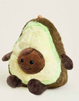 The Faire Avocado Warmies is a microwavable plush toy shaped like a smiling avocado with a brown seed belly, small arms and legs, offering extra comfort against a plain light background.