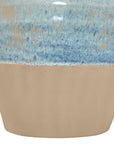 Close-up of the Moroson Vase by The Import Collection, a decorative ceramic vase with a matte tan base and glossy, textured blue upper section displaying speckled, uneven color blending.