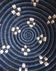 Close-up of the Kabaya Small bowl lid by Amsha - Faire, showing dark blue and white concentric circles in a spiral pattern with evenly spaced white accents radiating from the center.