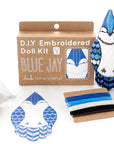 The Faire Blue Jay Embroidery Kit includes a box, pre-printed fabric, colored threads (blue, black, white), stuffing, sewing instructions, and lets you make a charming embroidered Blue Jay doll.