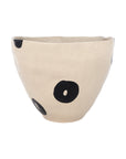 The Import Collection’s Clyde Bowl is a beige ceramic piece featuring an uneven rim, matte finish, and bold black spots—ideal as a modern decorative centerpiece.