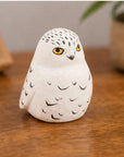Hand-carved wood songbird figurine by Faire displayed on wooden surface, ideal for nature-inspired decor.