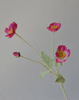 The Faire 22'' Single Flocked Floral Poppy Spray features four pink silk blossoms and green leaves on an elegant stem, beautifully displayed against a plain, light gray background.
