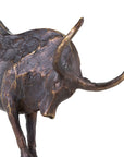 A close-up of The Import Collection’s Bull Statuary highlights its textured bronze finish, lowered head, and curved horns—an eye-catching home decor piece.
