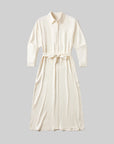 The Camillia Shirt Dress in Portofino Twill by Citizens Of Humanity/AGOLDE is a cream, long-sleeved, collared shirt dress with a waist tie and button-down front, shown flat on a plain gray background—perfect for vacation.